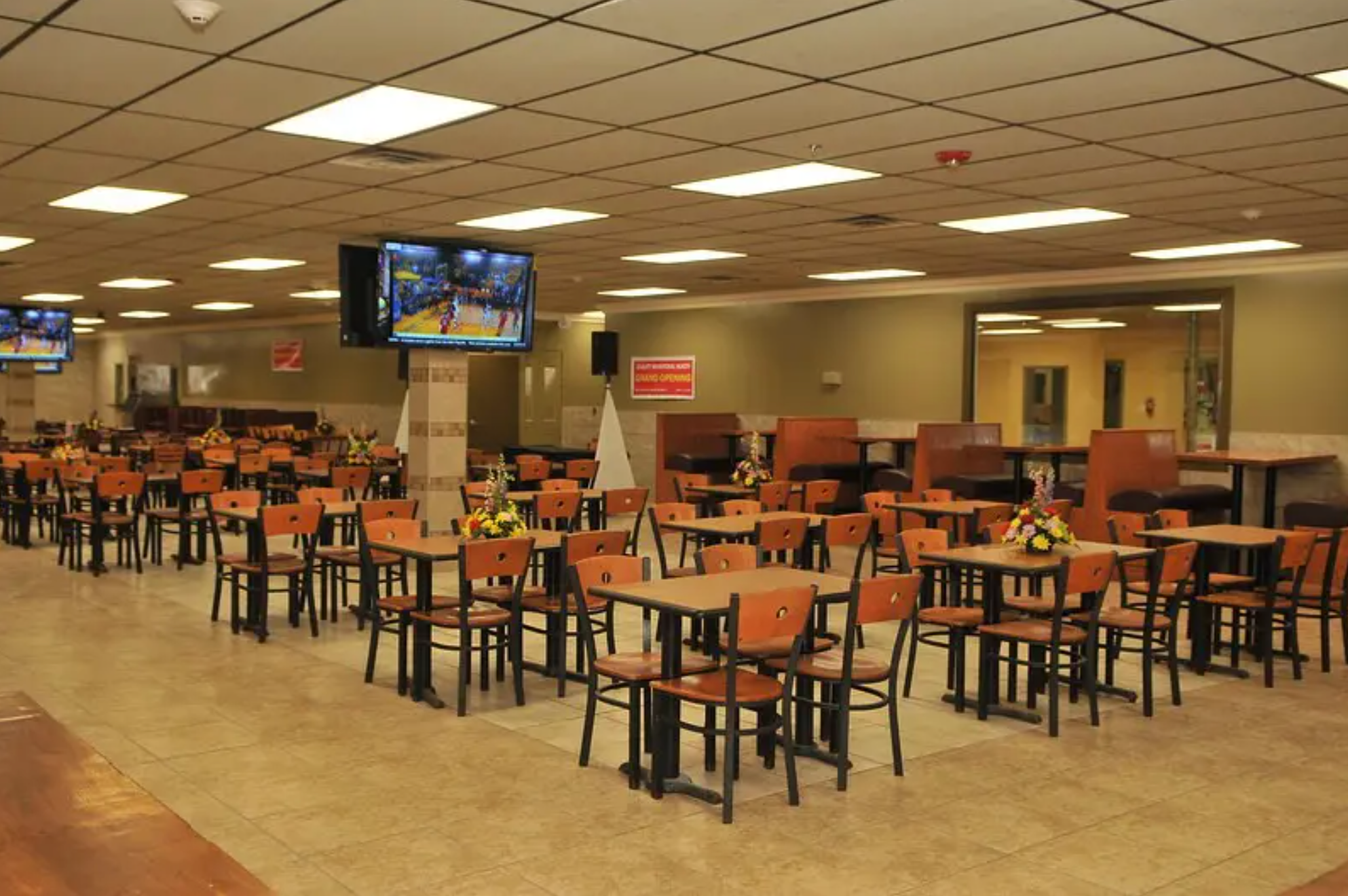 A large cafeteria with neatly arranged tables and chairs, ideal for group dining.