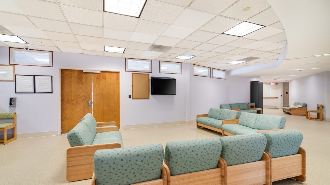 Waiting room with cushioned seating and TV