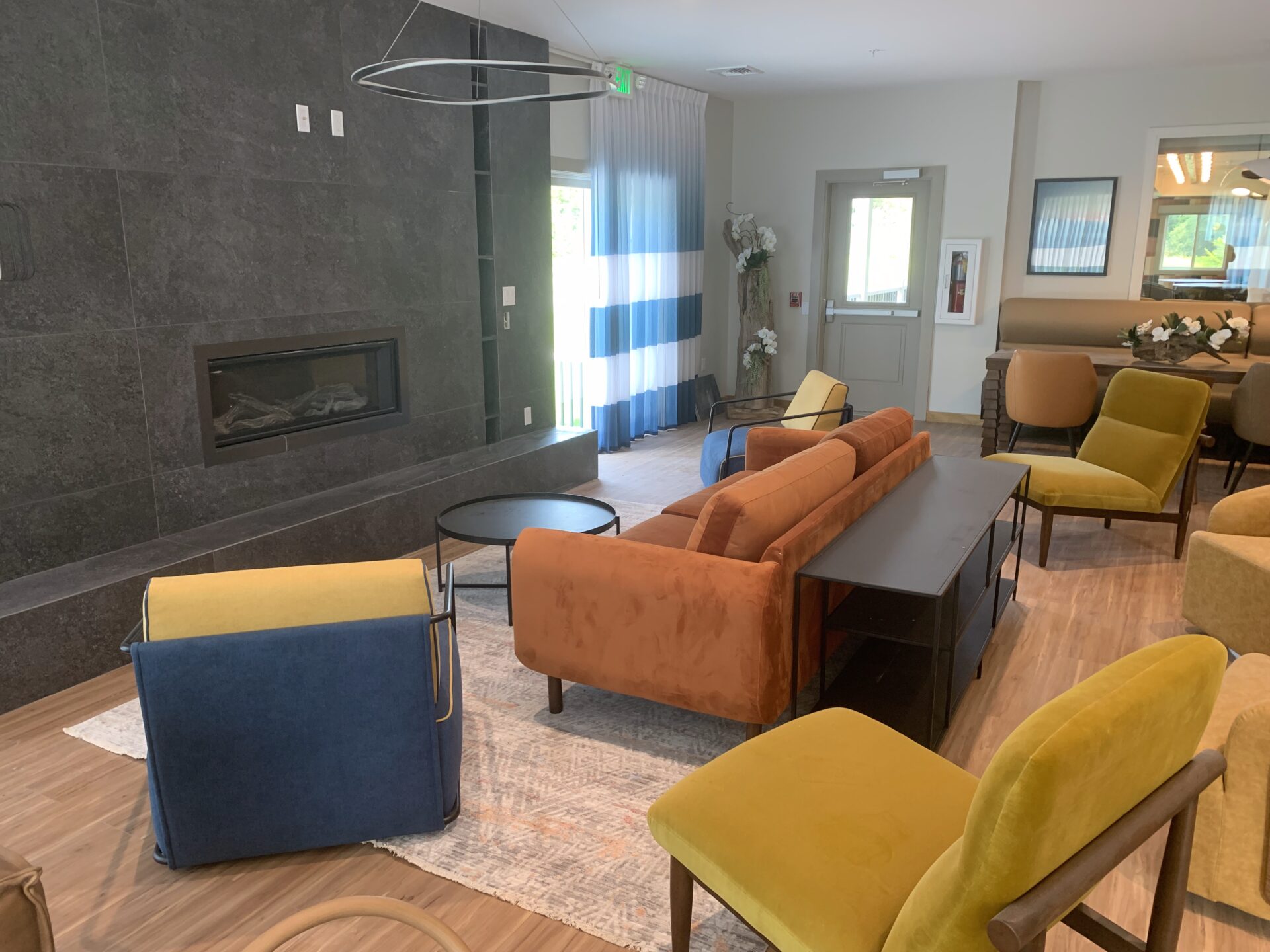 Living room with colorful furniture and a fireplace.