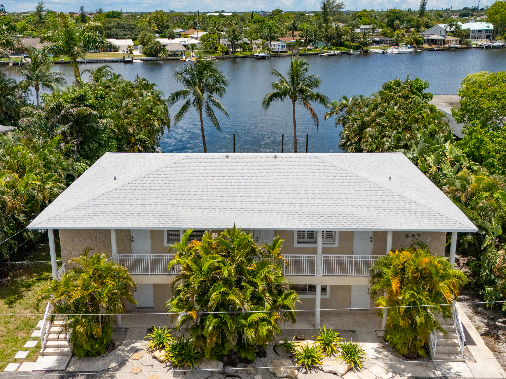 Aerial view of building near water and palm trees