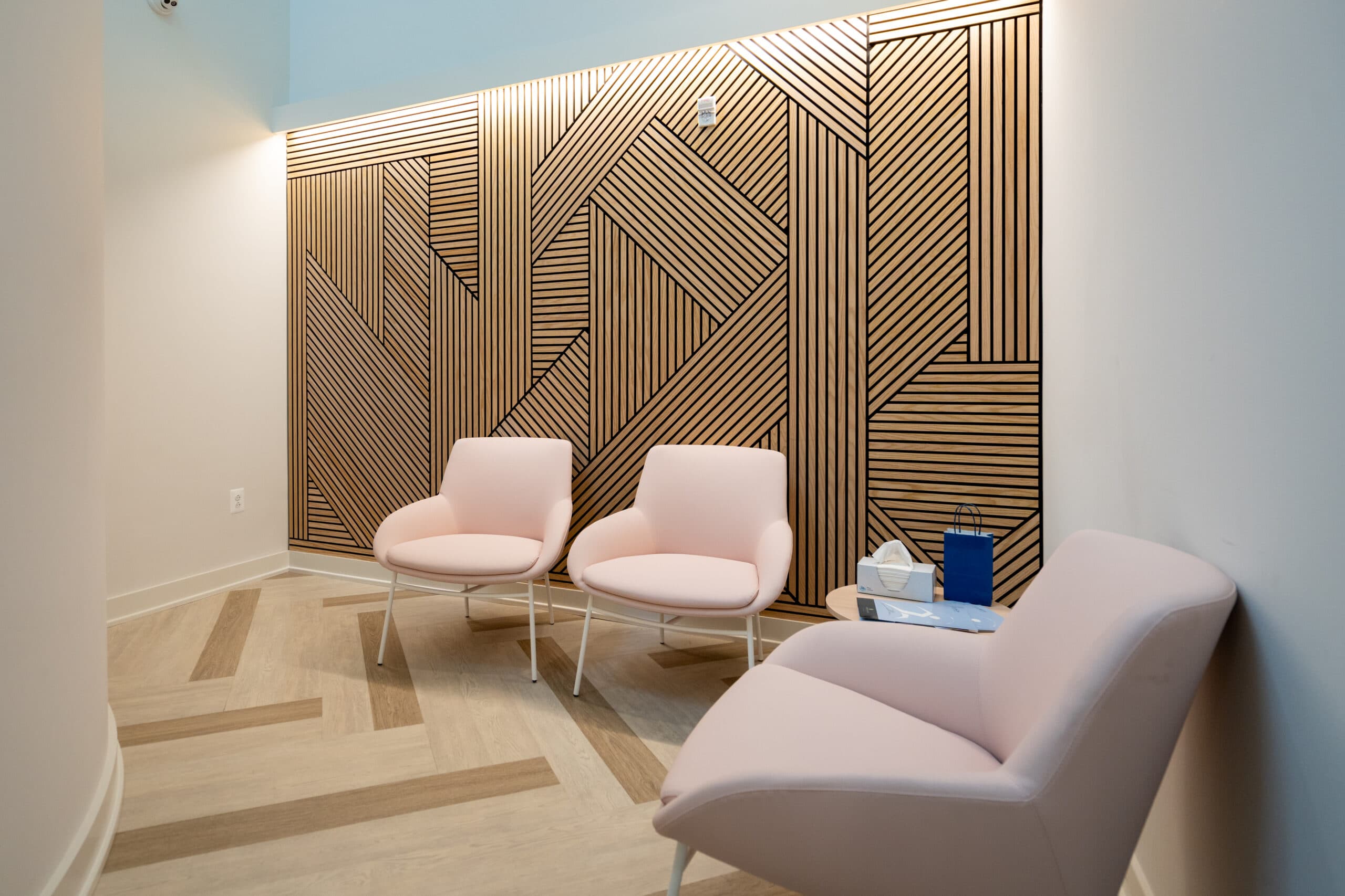 Pink chairs in stylish waiting room with wooden panel wall