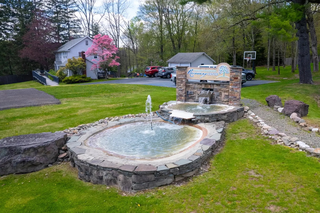 Stone sign with fountains and parking area nearby