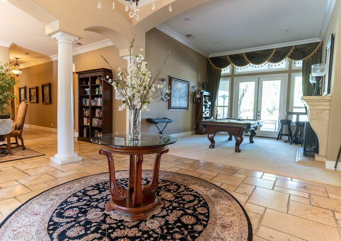Room with pool table and grand windows