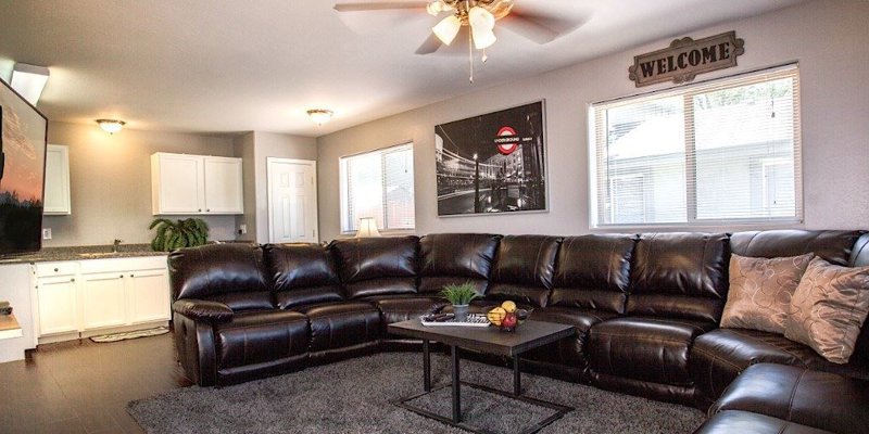 A cozy living room featuring a large leather sectional, modern decor, and a welcoming atmosphere perfect for relaxation and comfort.