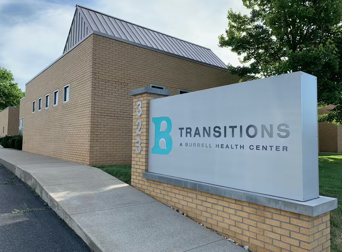 Front exterior of Transitions facility with building and sign visible