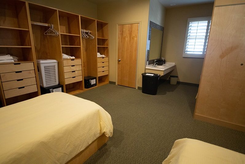 Shared bedroom with beds, storage cubbies, and sink area