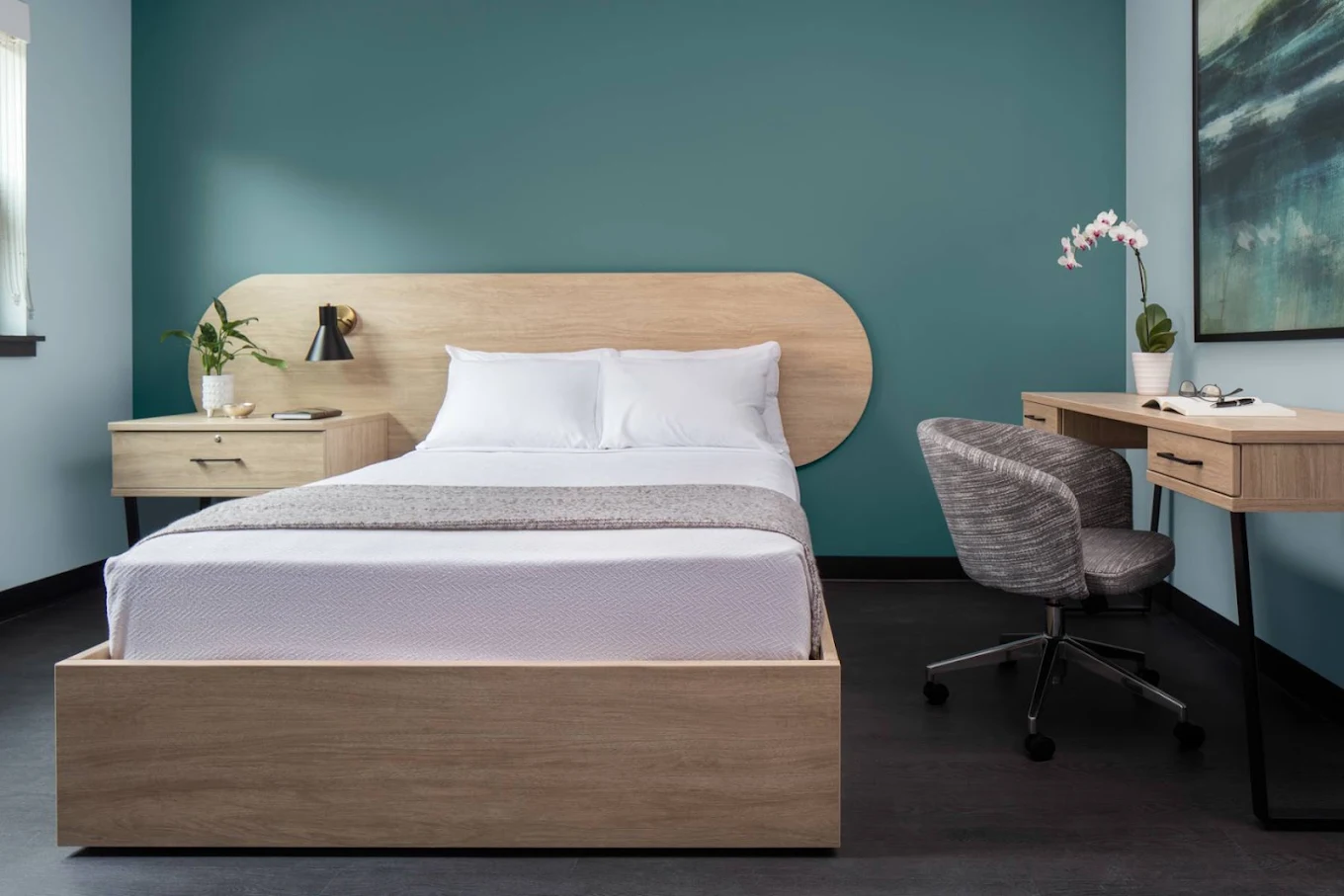 Private bedroom with bed, desk, chair, and teal accent wall