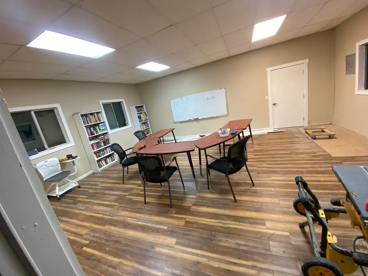Group room with tables, chairs, bookshelves, and whiteboard