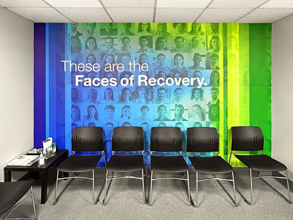 Chairs lined up in front of Faces of Recovery mural