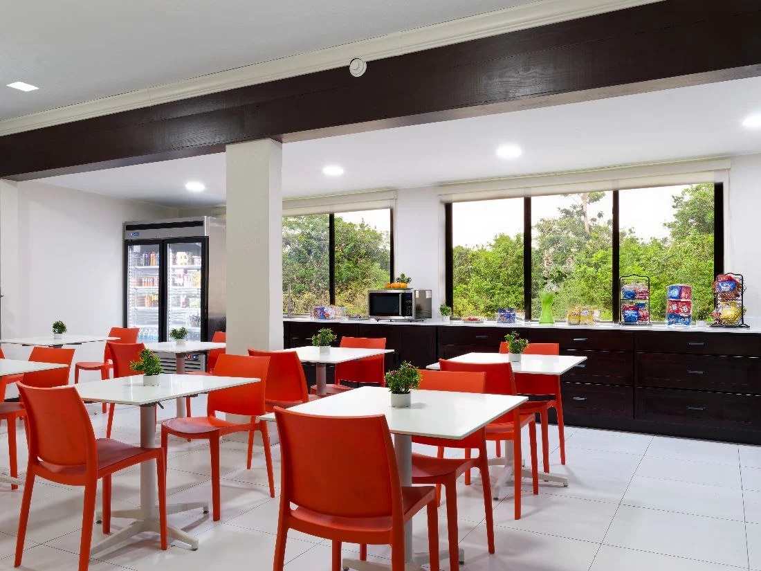 Bright cafeteria with red chairs and snack displays