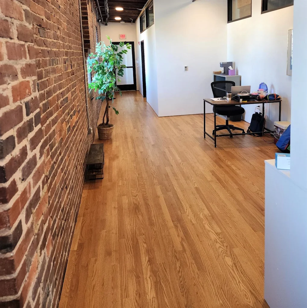 Reception area with exposed brick wall and wood flooring at Master Center Harrisonburg