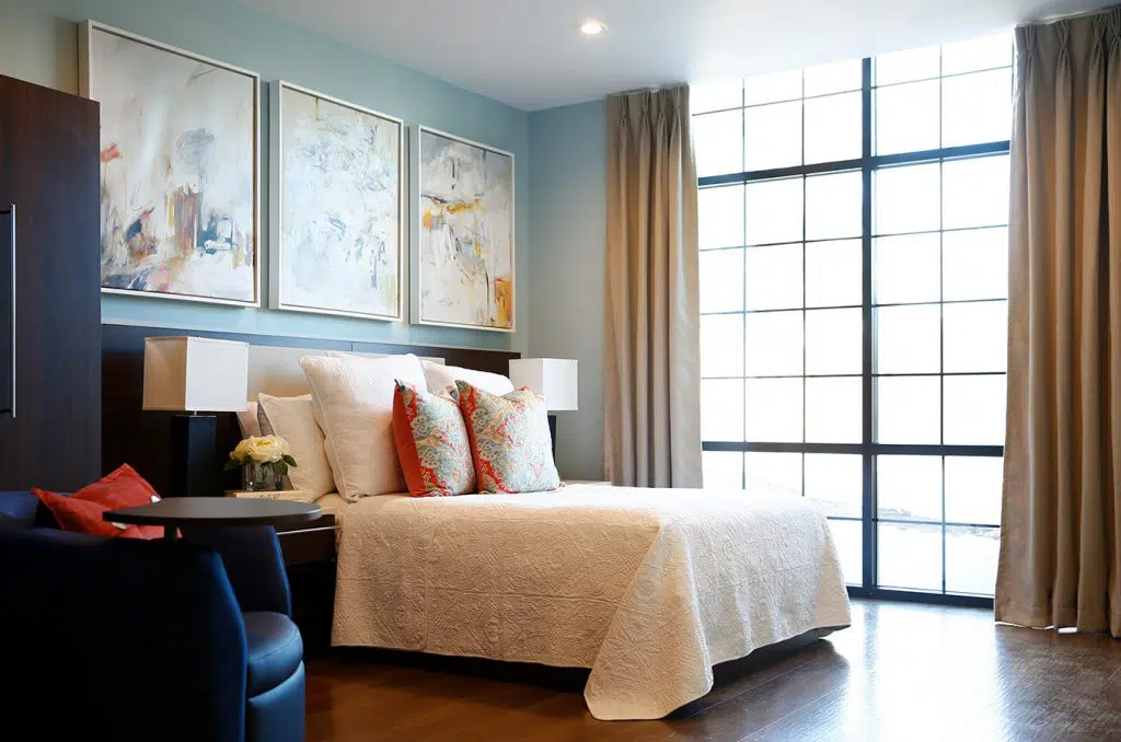 Cozy bedroom with art, pillows, and large window