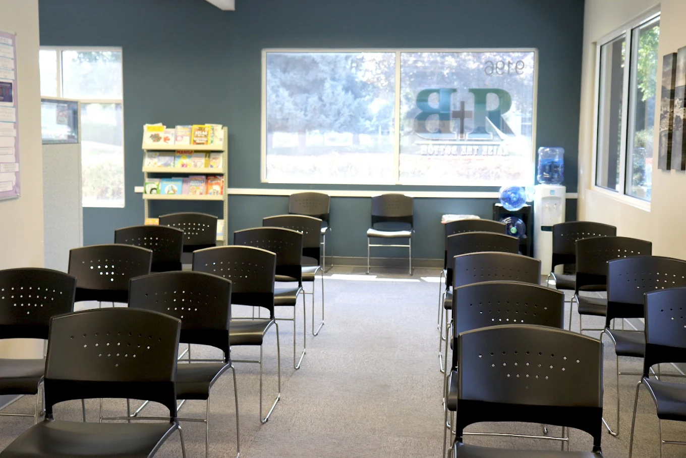 Chairs arranged for group session near window and bookshelf