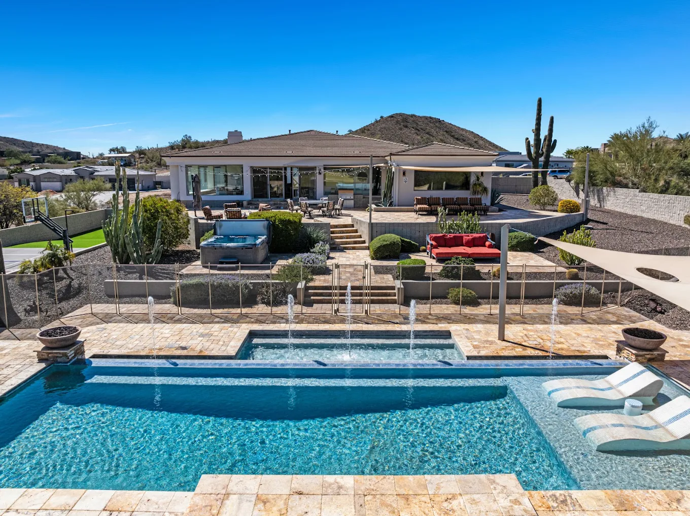 Backyard with pool, spa, seating, and mountain backdrop