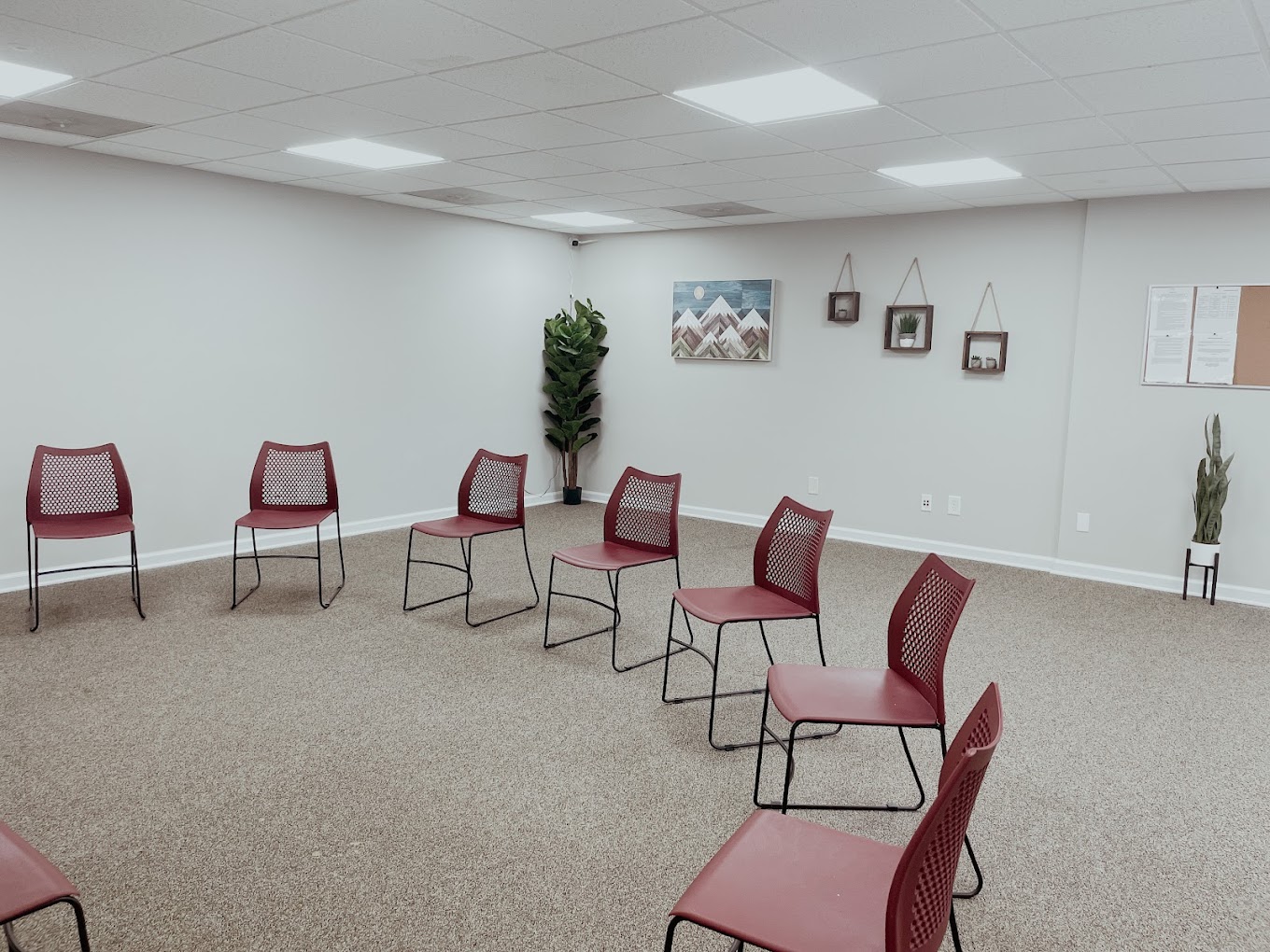 Therapy room with red chairs arranged in a circle.