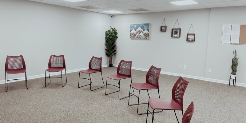 Therapy room with red chairs arranged in a circle.