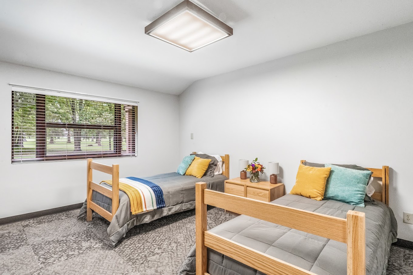 Shared bedroom with two twin beds and colorful pillows.