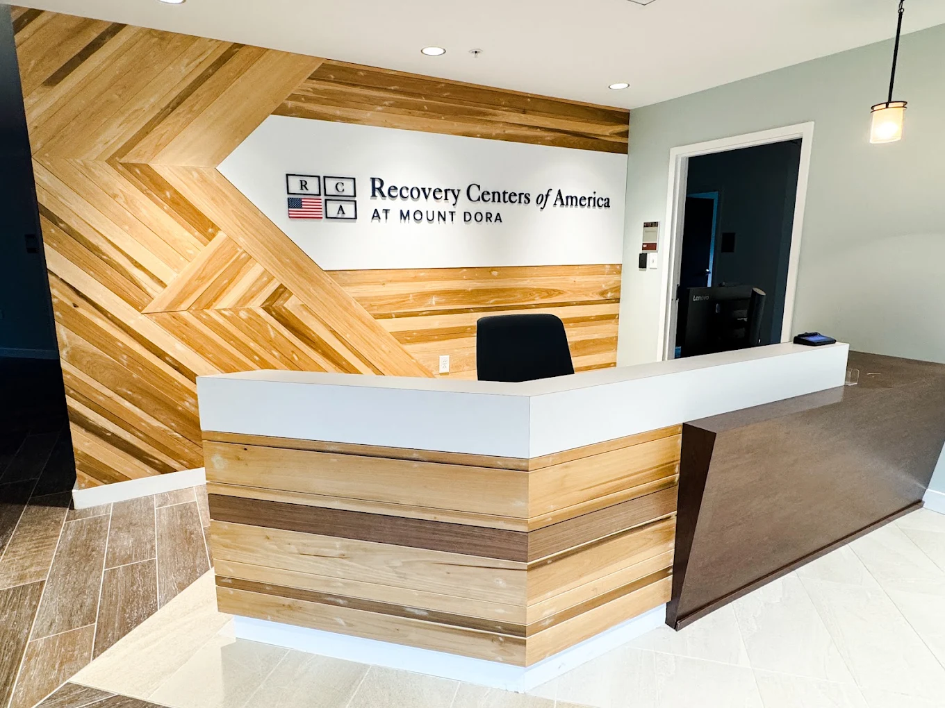 Reception desk with RCA at Mount Dora signage on wood wall