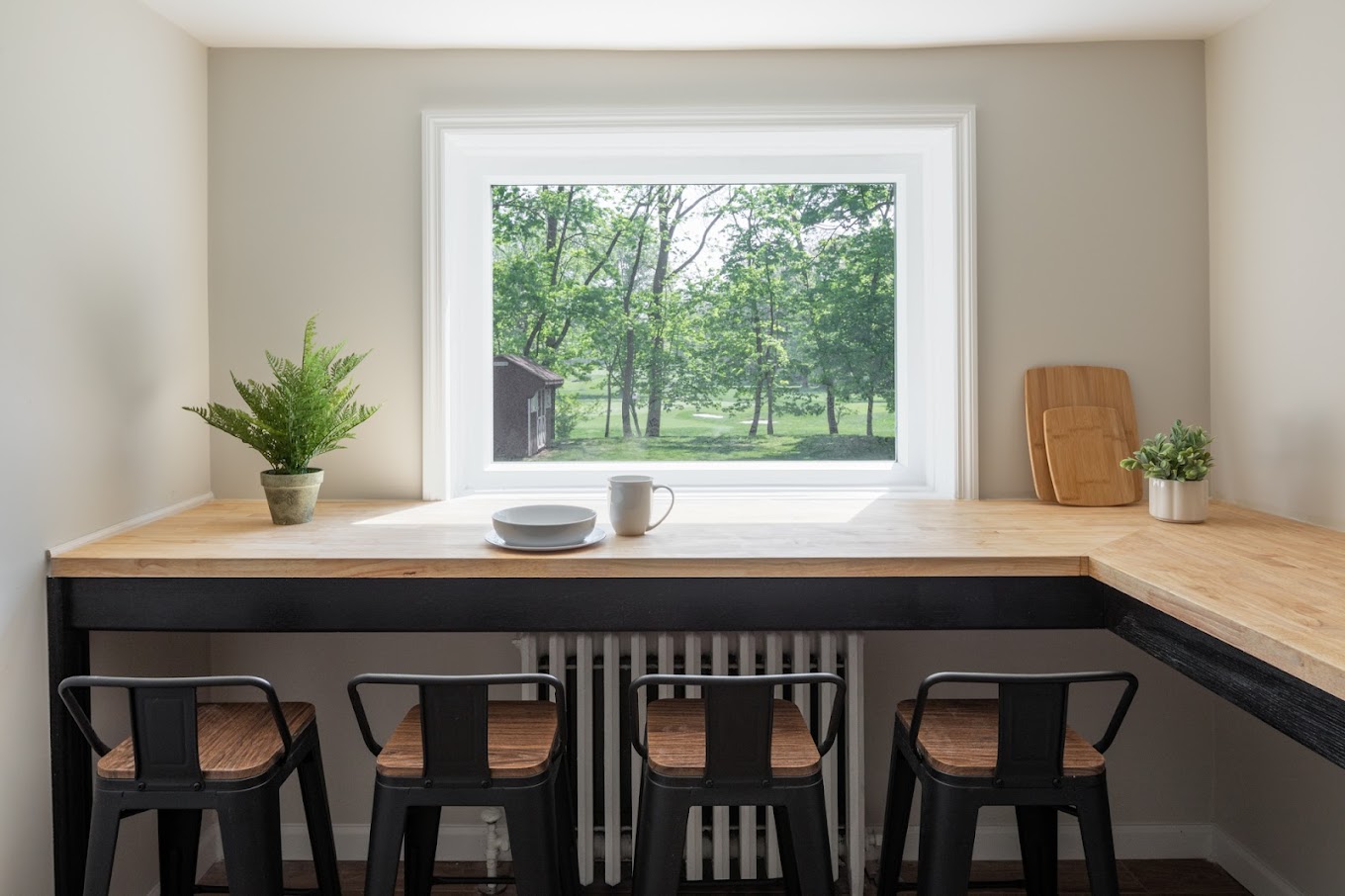 Breakfast nook with a countertop,  stools, and a window.
