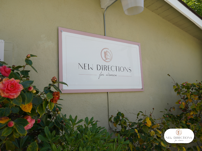 New Directions for Women sign surrounded by blooming roses