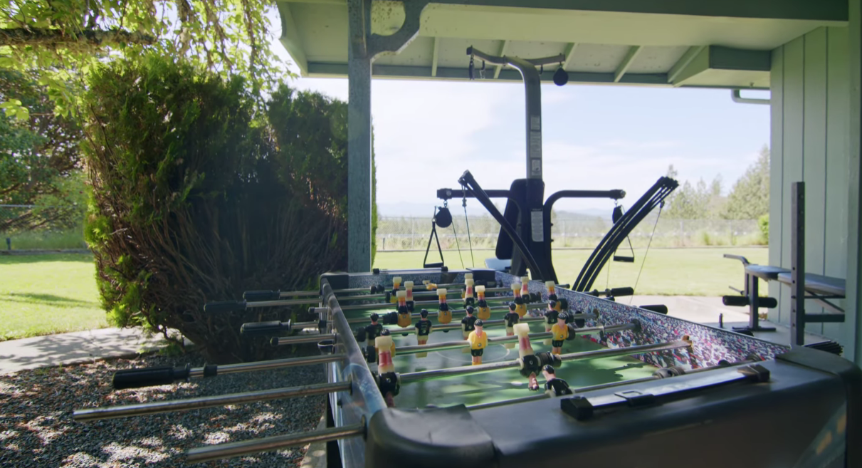 Covered outdoor area with foosball table and gym equipment