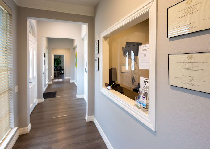 Reception hallway with a service window and framed certificates.