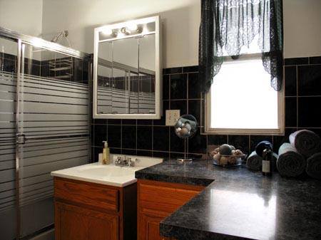 Modern bathroom with black tile and glass shower