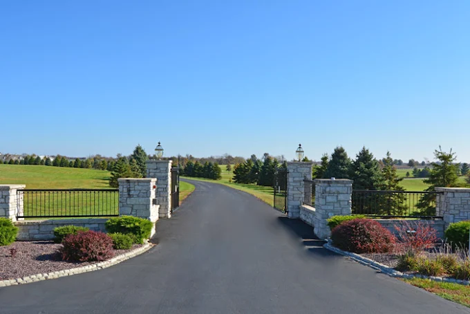 Paved driveway with stone gate and lantern lights