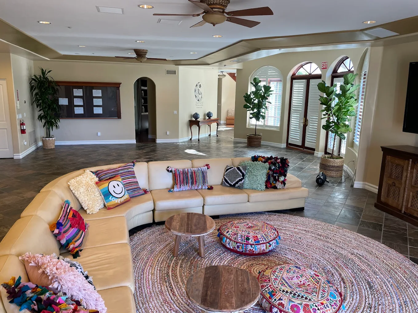 Curved sofa with bright pillows in open lounge space