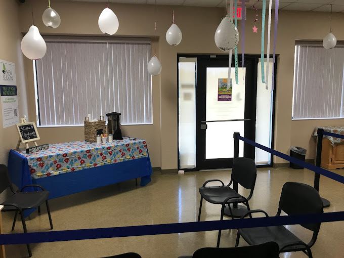 Waiting area with a refreshment table and chairs.