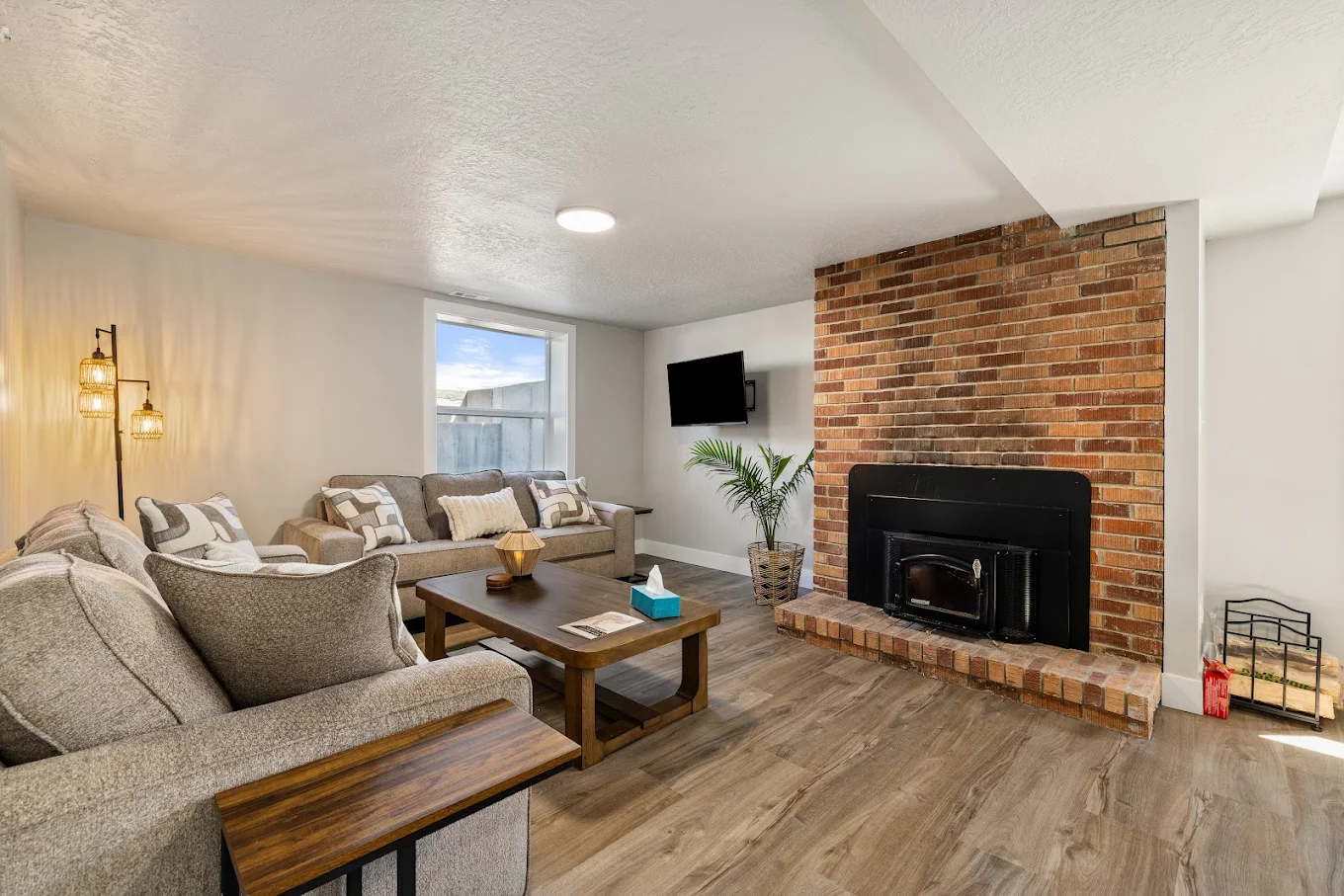 Lounge with sofas, brick fireplace, coffee table, and TV