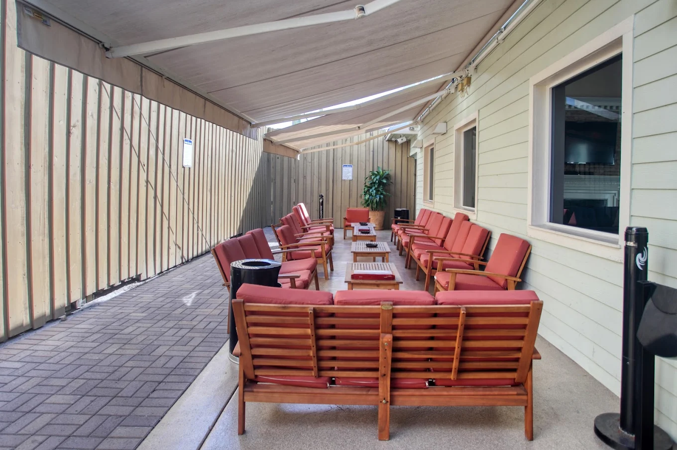 Covered patio with red cushioned chairs arranged in rows