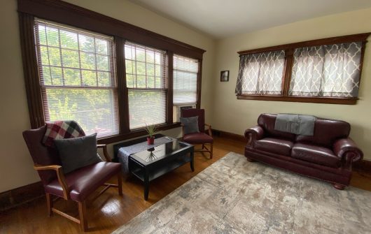 Cozy lobby with red leather sofa, chairs, and large windows