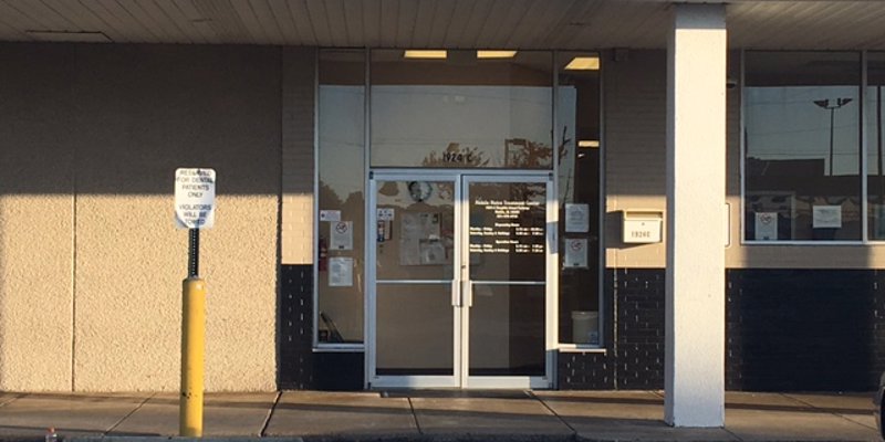  The front entrance of a building with large glass doors, clear signage, and a clean walkway, creating an inviting and professional look.