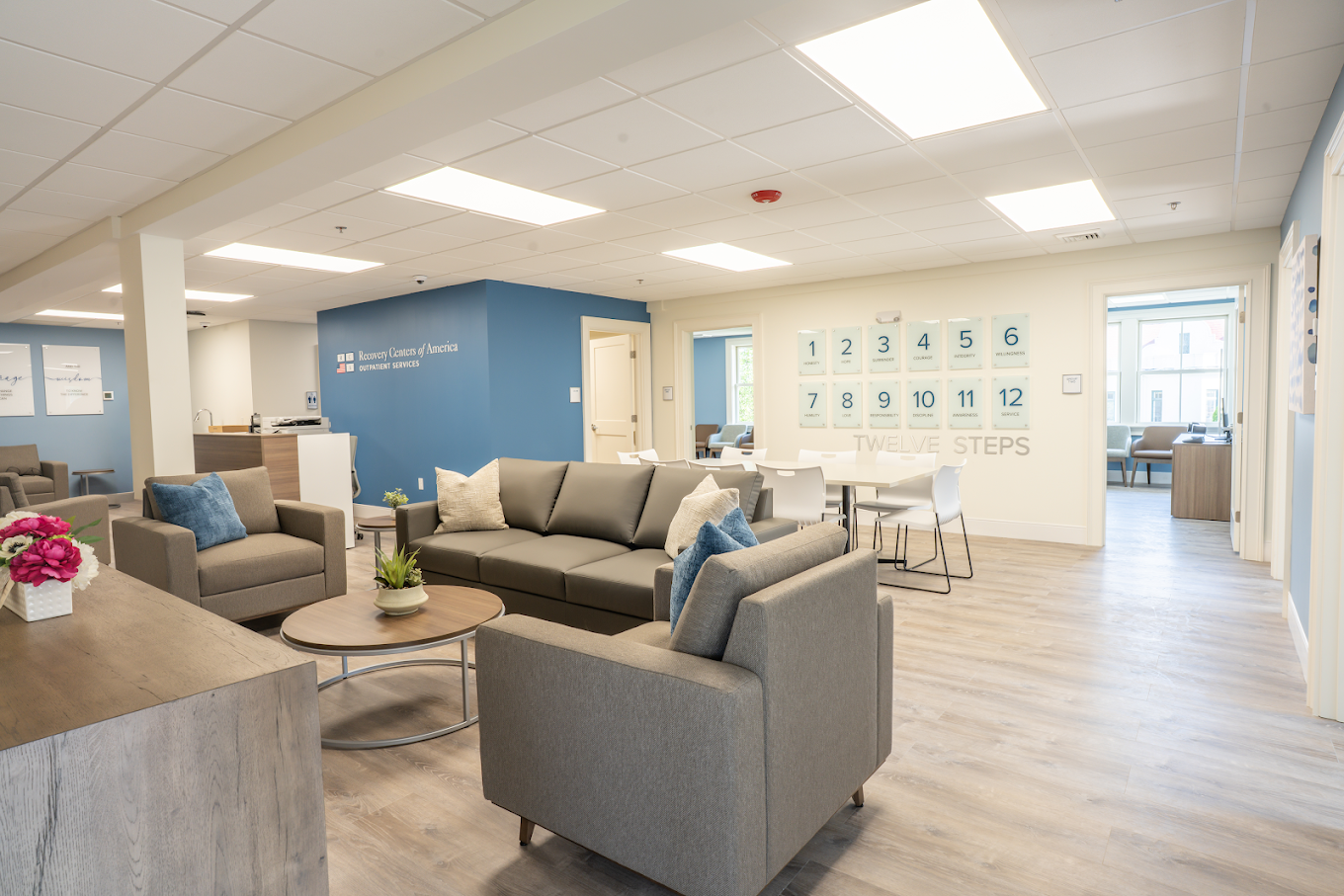 Lounge with sofas, tables, and Twelve Steps displayed on wall
