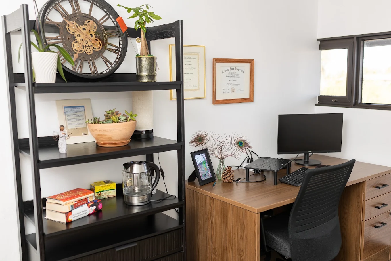 Office with desk, computer, shelving, and framed decor