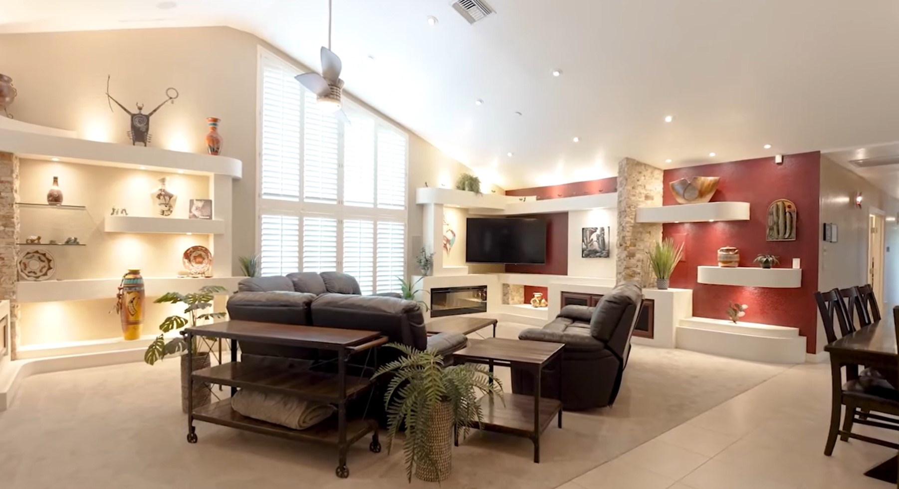 Lounge area with black couches, TV, and windows.