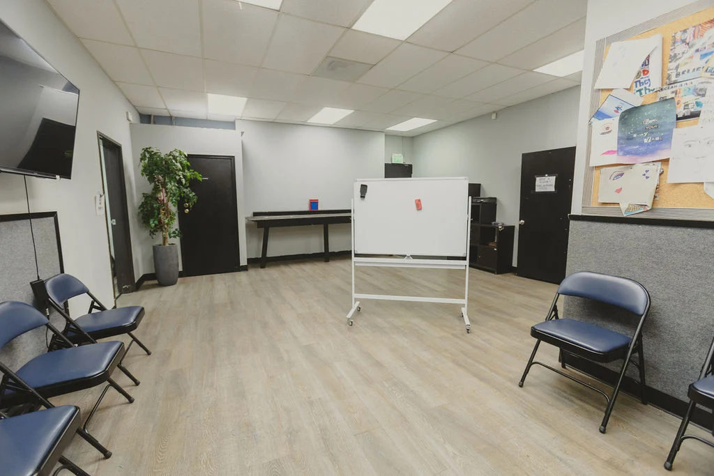 Classroom with chairs, whiteboard, television, and bulletin board