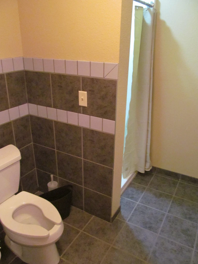Residential bathroom with tiled shower and private toilet