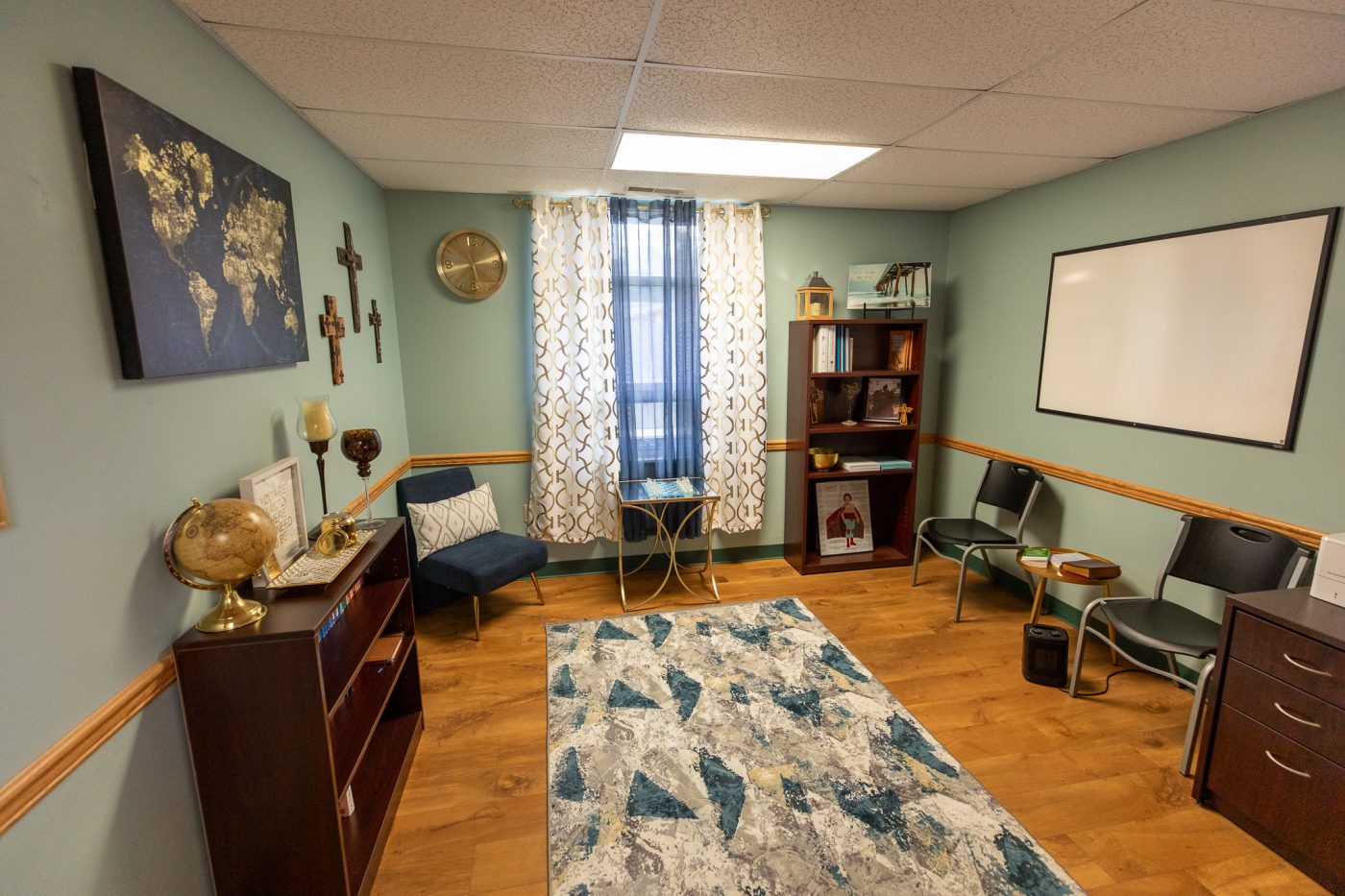 Private counseling office with seating area, bookshelf, and calming blue decor inside treatment center