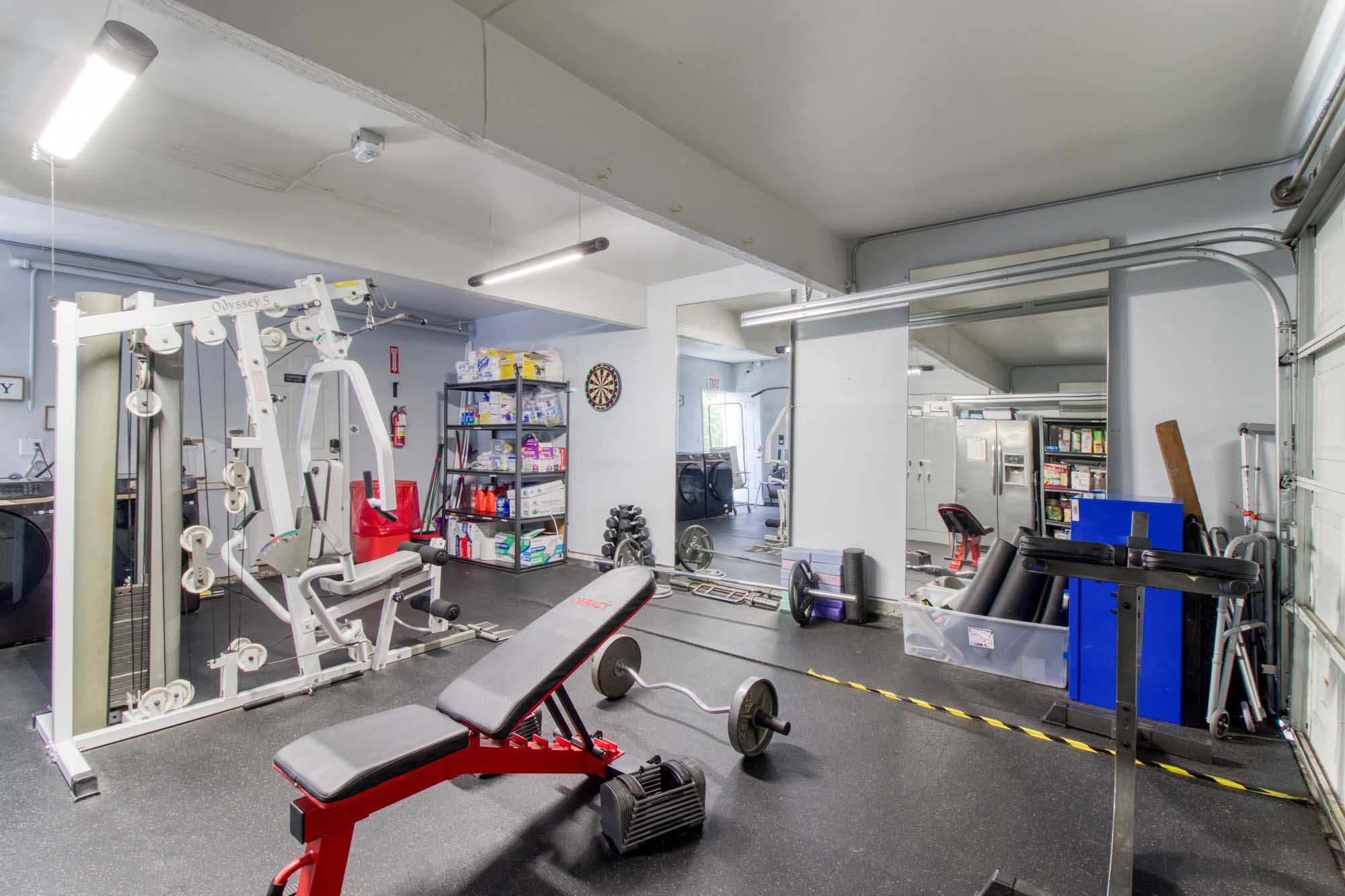 Indoor fitness room with weights, bench, and exercise machines
