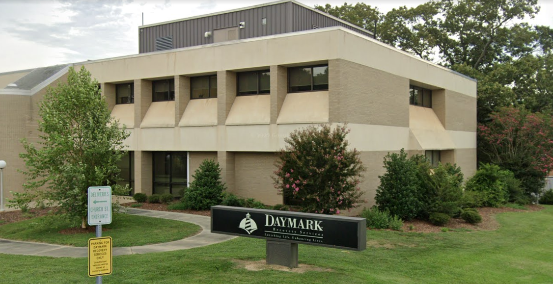 Entrance walkway with trees and signage near building front