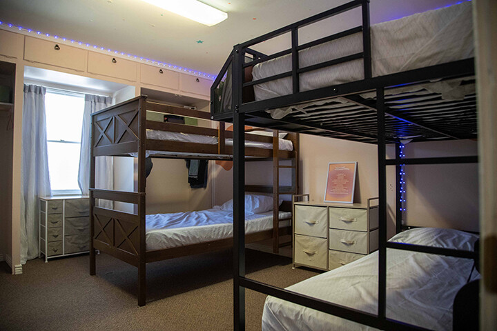 Shared bedroom with wooden and metal bunk beds and dressers