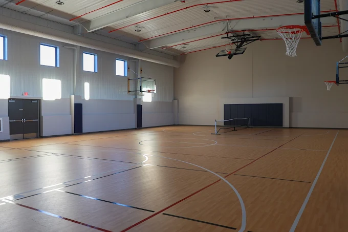 Basketball court with wood flooring and high ceiling