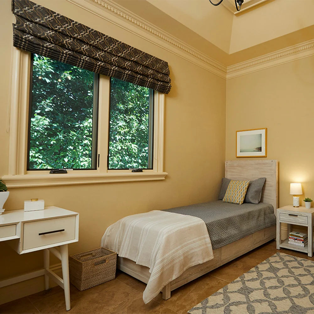 Cozy single bedroom with desk and window view