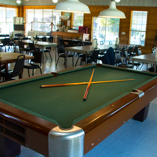 Pool table and dining area with large windows