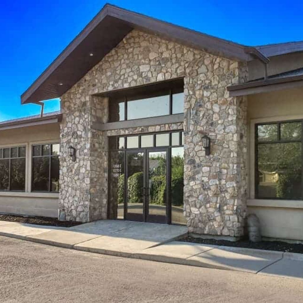 Stone facade with double glass doors and awning