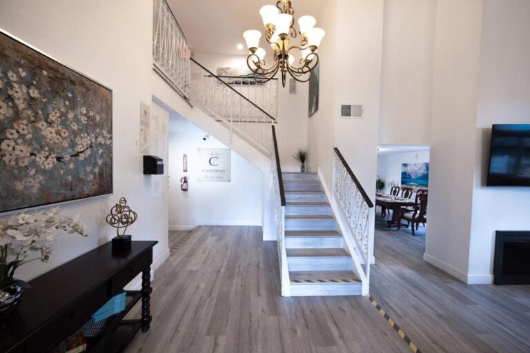 Elegant room with fireplace, leather seating, and staircase