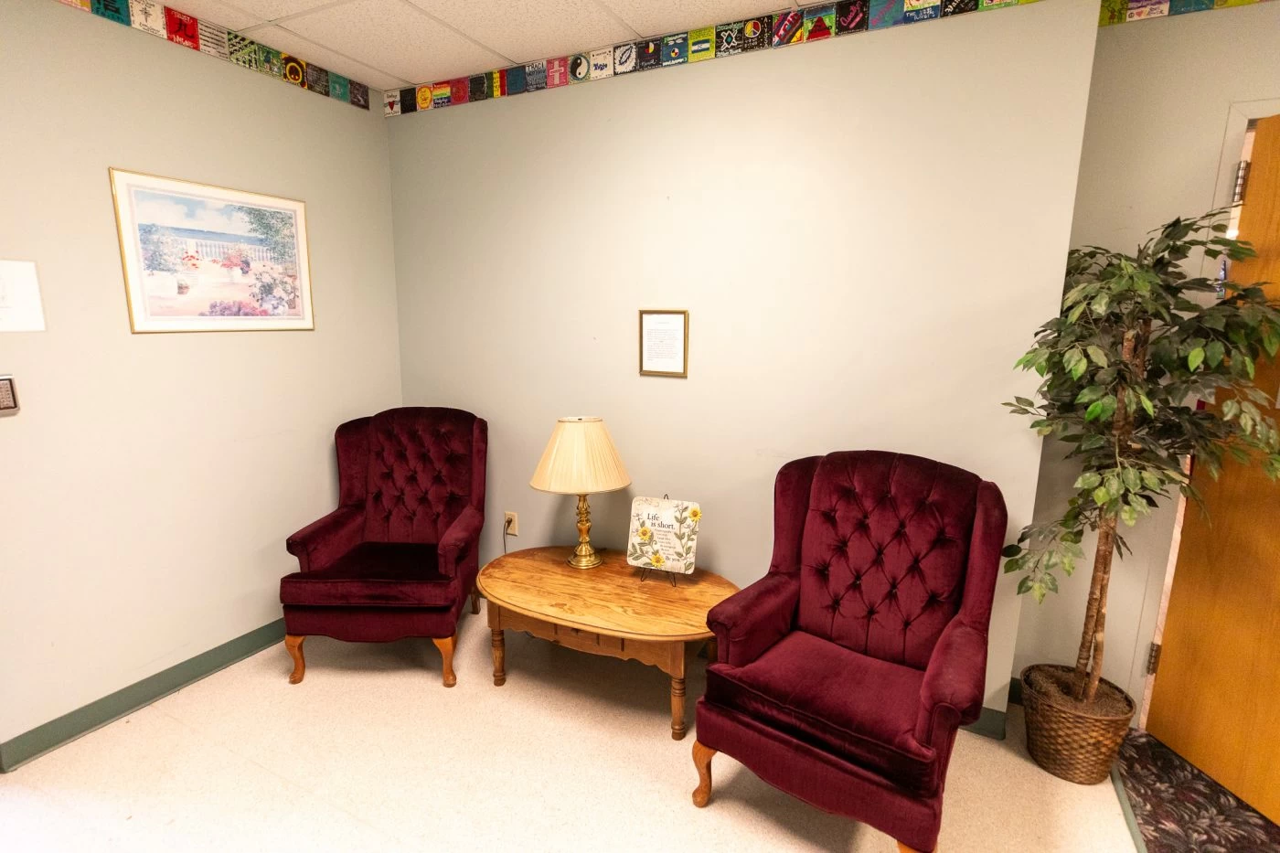 Quiet seating area with upholstered chairs, lamp, and calming decor inside recovery center