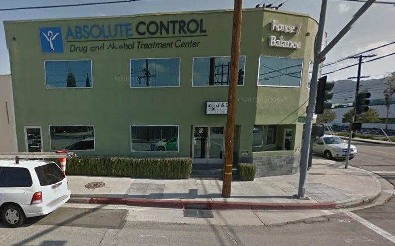Green corner building with Absolute Control sign and logo